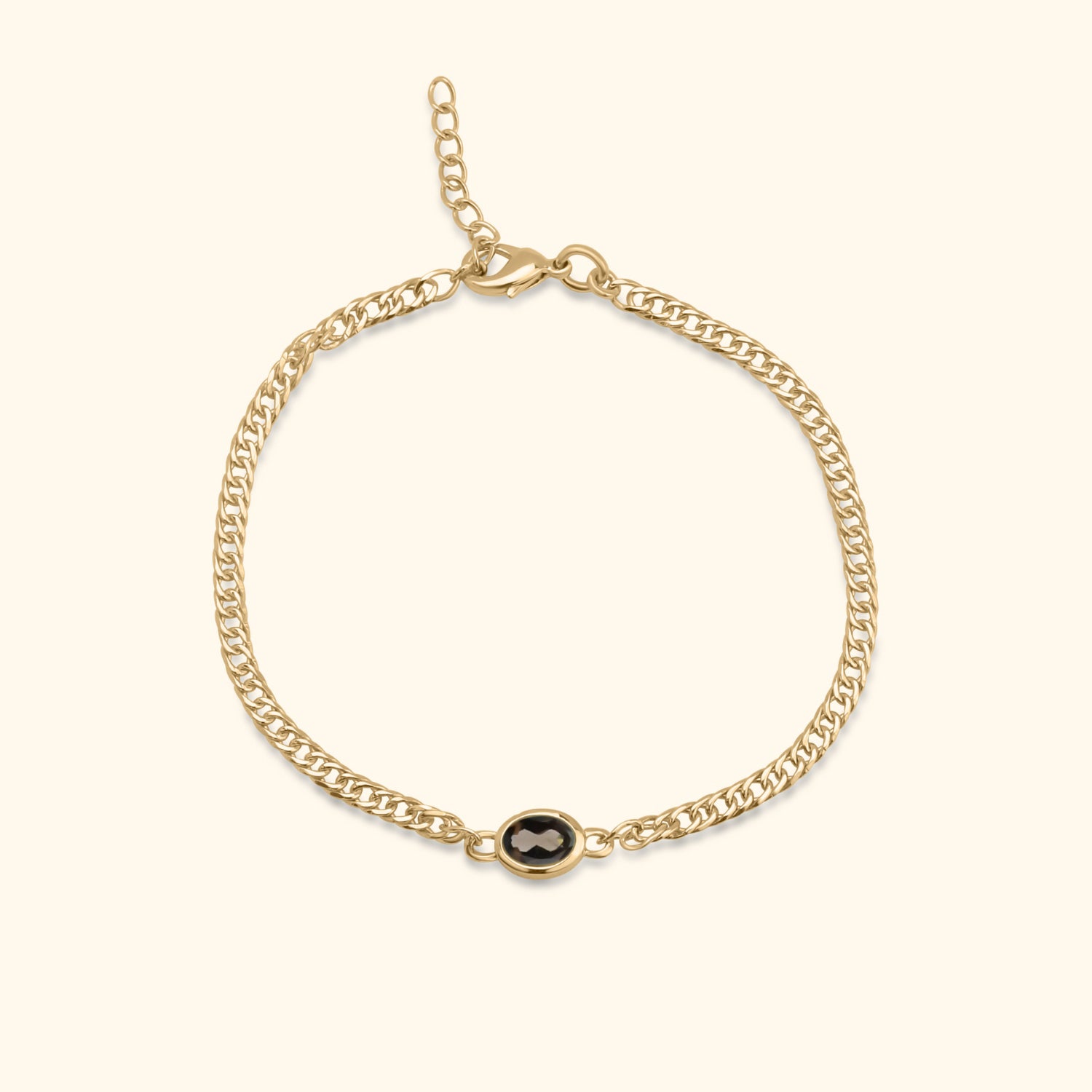 Goudkleurige armband met ovale bruine steen in het midden op een lichte achtergrond.